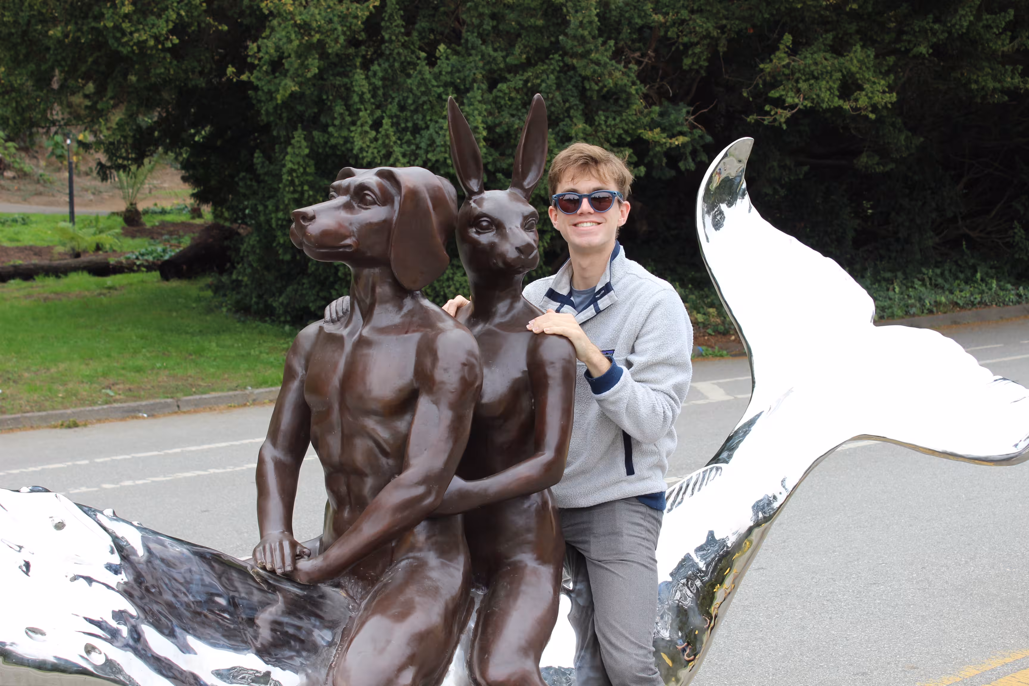Me sitting on a sculpture on JFK. The sculpture is of a human-like dog and human-like bunny riding a whale.